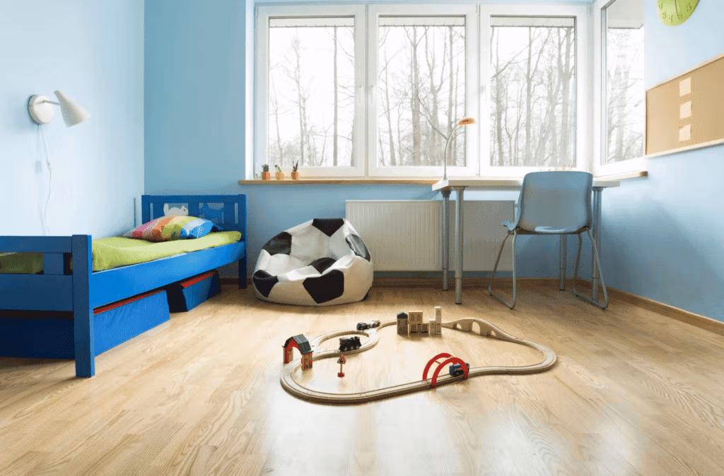 Chambre d’enfant avec parquet clair, lit et murs peints en bleu, créant une ambiance fraîche qui évoque la sensation de froid.