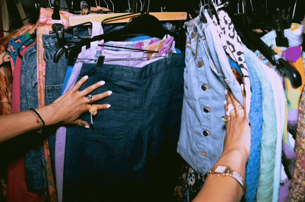 Deux femmes en train de faire du shopping dans une boutique de mode, en pleine sélection de vêtements.
