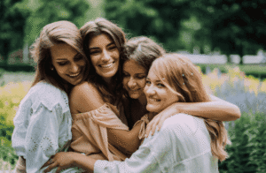 Quatre jeunes filles souriantes se prenant dans les bras.