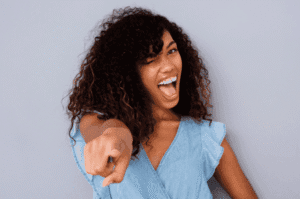Jeune femme souriante pointant du doigt avec enthousiasme.